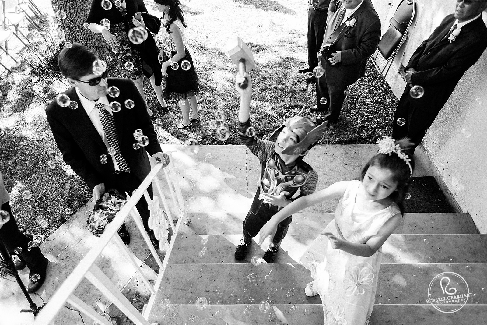 Ring bearer dressed at Thor pops bubbles with hammer – Altadena Backyard Wedding – Russell Gearhart Photography – www.gearhartphoto.com
