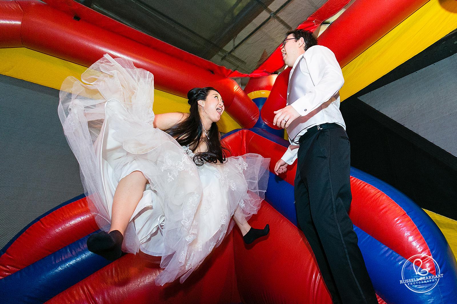 Bride and Groom Jumping in Wedding Bouncy House - ArcTek Studios Wedding in Monrovia – Russell Gearhart Photography – www.gearhartphoto.com